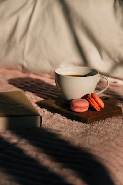 macaroons de café e um livro na cama