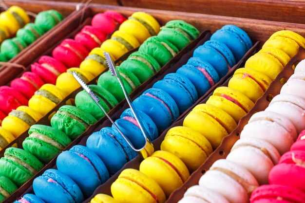 Macaroons de colorido. Doces tradicionais com pinças de prata