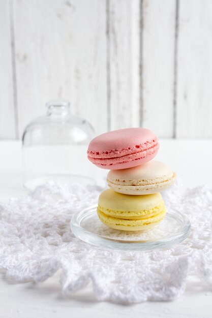 Macaroons de francês coloridos em um branco de madeira