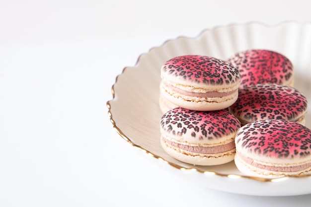 Macaroons doces de framboesa e baunilha com desenho de leopardo no prato