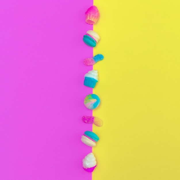 Macaroons e mistura doce em fundo colorido. arte culinária elegante e plana