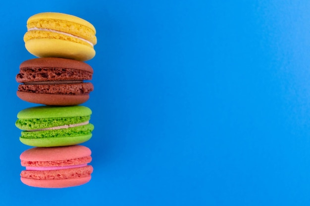 Macaroons em um fundo azul claroCopiar espaçoCookies franceses de amêndoa