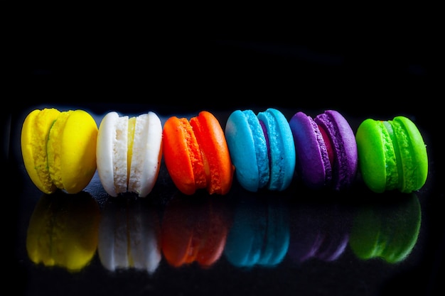 Macaroons franceses coloridos em um preto.