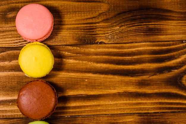 Macaroons franceses em uma mesa de madeira rústica. Vista do topo