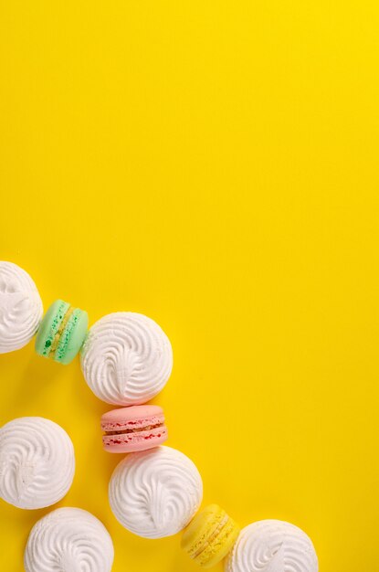 Macaroons multicoloridos ou macarons e merengues com um espaço para texto em amarelo b