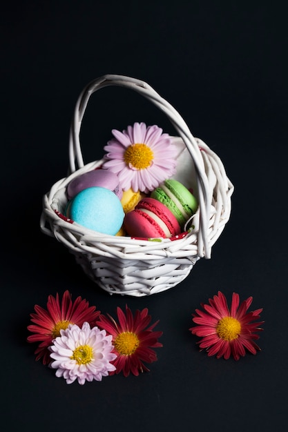 Macaroons na cesta em fundo preto