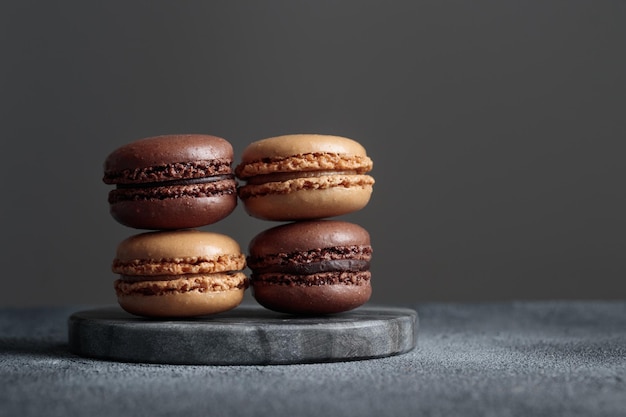 Macaroons naturais feitos à mão de chocolate eco em fundo escuro no estilo darkmood