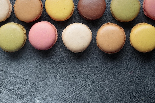 Macaroons naturais feitos à mão de eco pastel coloridos em fundo escuro Presente para 8 de março, Dia Internacional da Mulher, Dia dos Namorados, vista superior