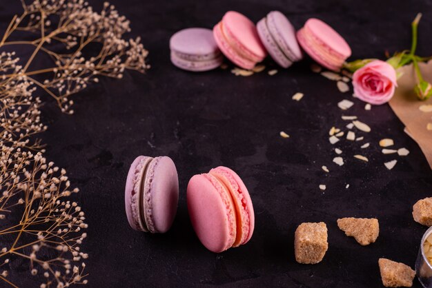 Macaroons saborosos rosa lindos sobre um fundo de concreto