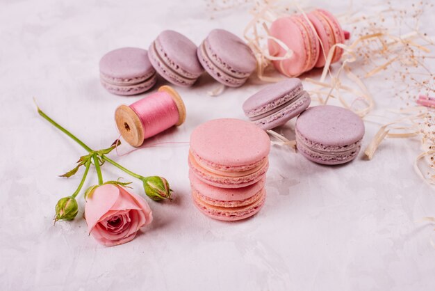 Macaroons saborosos rosa lindos sobre um fundo de concreto