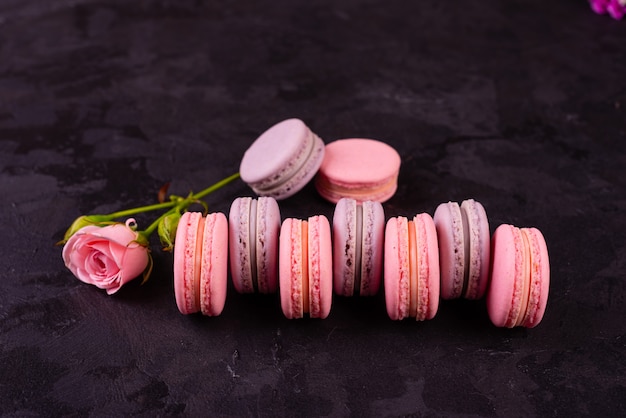 Macaroons saborosos rosa lindos sobre um fundo de concreto