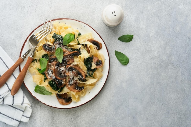 Macarrão Alfredo cremoso Fettuccini de macarrão italiano com cogumelos carne de frango espinafre manjericão e molho de creme em pedra cinza ou fundo de concreto Cozinha tradicional italiana Flat lay Espaço para cópia