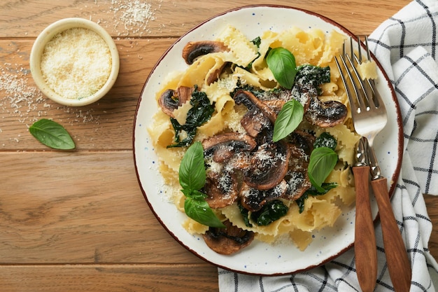 Macarrão Alfredo cremoso Fettuccini de macarrão italiano com cogumelos carne de frango espinafre manjericão e molho de creme no antigo fundo de mesa rústica Cozinha italiana tradicional Flat lay Espaço para cópia