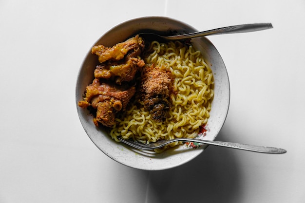 macarrão amarelo com frango e molho de pimentão verde em cima isolado em fundo branco