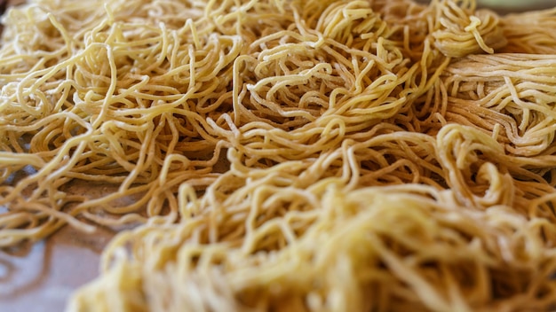 Macarrão amarelo em uma bandeja na mesa da cozinha