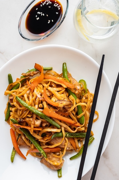 Macarrão asiático com carne de porco em molho teriyaki, com feijão verde, cenoura e cogumelos shiitake.