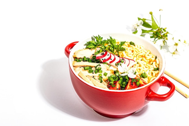 Macarrão asiático com legumes de frango e ervas são isolados em um fundo branco