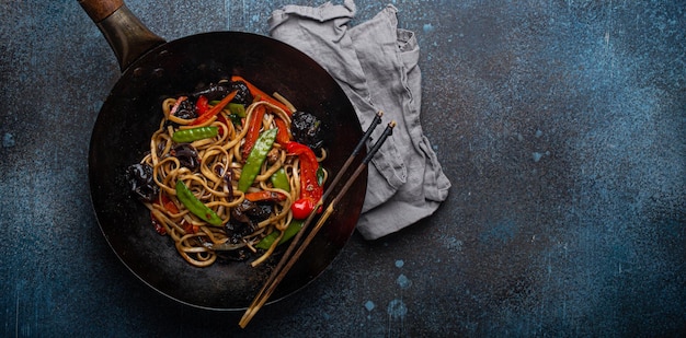 Macarrão asiático com legumes em cópia de panela wok preta