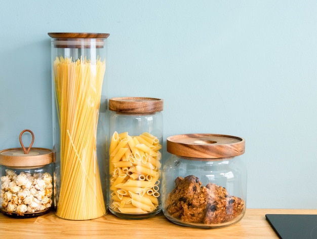 Foto macarrão, biscoito e massa estão guardados no pote