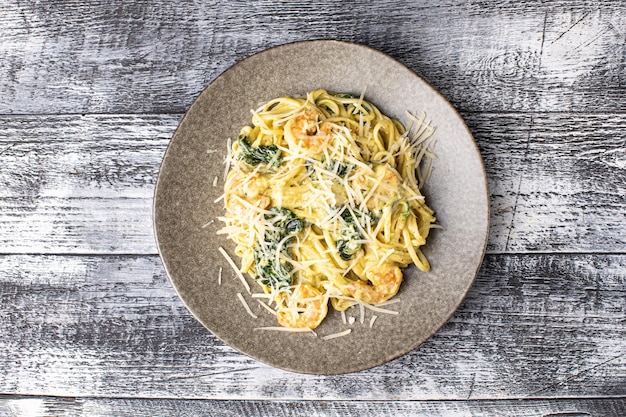 Macarrão carbonara belenese com frango em um fundo branco de madeira