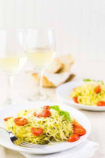 Macarrão caseiro de cabelo de anjo com molho pesto e tomate cereja assado.