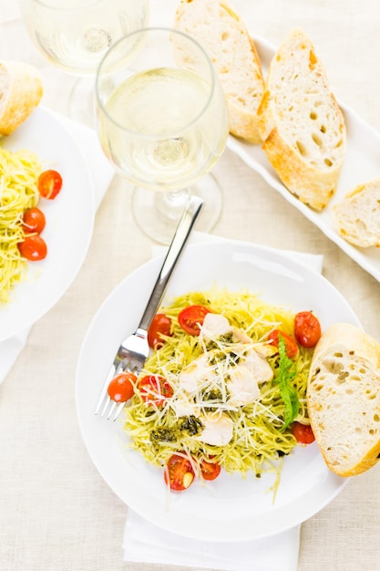 Macarrão caseiro de cabelo de anjo com molho pesto, tomate cereja assado e frango grelhado.