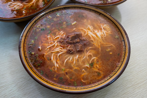 Foto macarrão chinês com carne em sopa picante