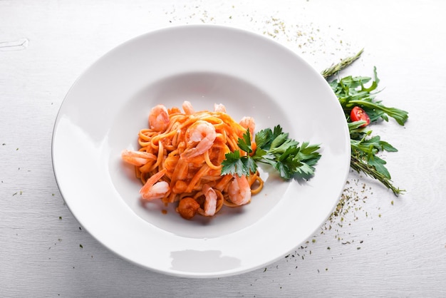 Macarrão com camarão e molho de tomate Comida tradicional italiana Em um fundo de madeira Vista superior Espaço livre para o seu texto