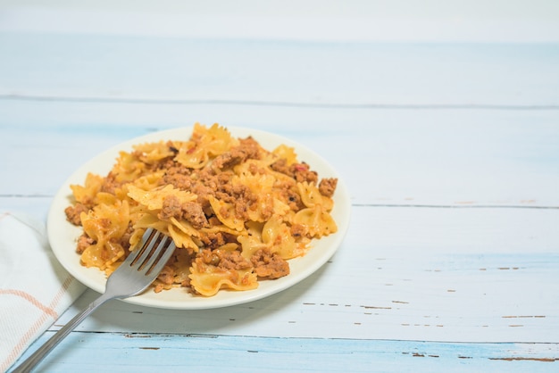 Macarrão com carne em uma luz. macarrão em forma de uma borboleta com carne.