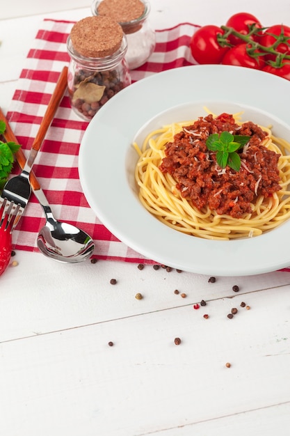 Macarrão com carne, molho de tomate e legumes em cima da mesa