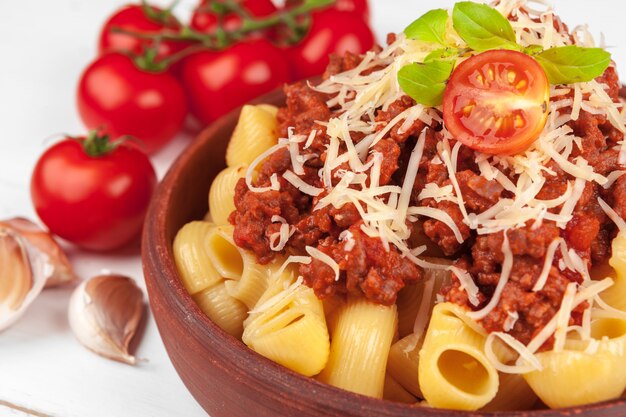 Macarrão com carne, molho de tomate e legumes em cima da mesa