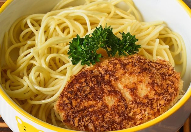 Macarrão com costeleta de carne servida como menu infantil close-up