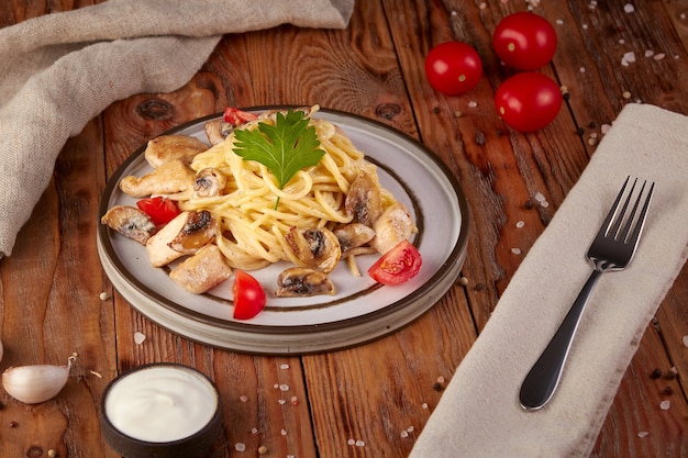 Macarrão com frango e cogumelos, cozinha italiana, fundo de madeira