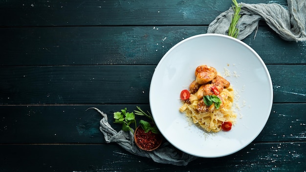 Macarrão com Frango e Parmesão. Em um fundo de madeira. Vista do topo. Espaço livre para o seu texto.