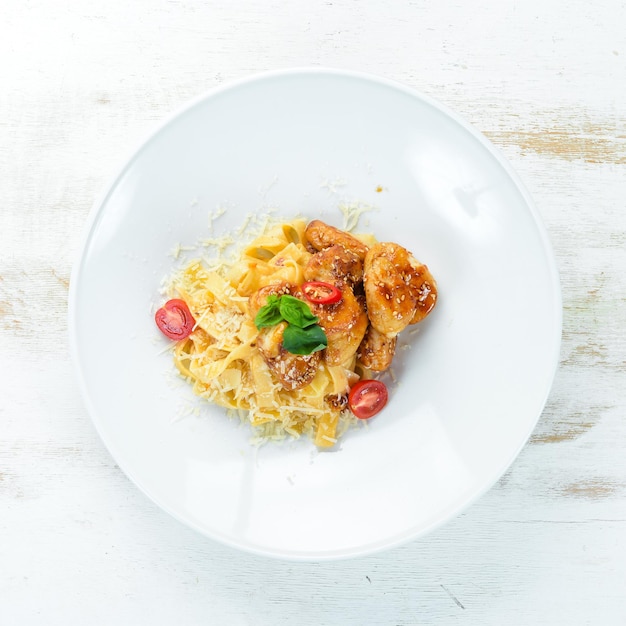 Macarrão com Frango e Parmesão. Em um fundo de madeira. Vista do topo. Espaço livre para o seu texto.