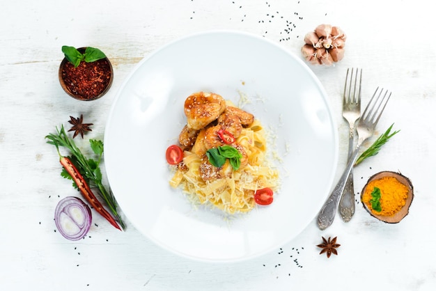 Macarrão com Frango e Parmesão. Em um fundo de madeira. Vista do topo. Espaço livre para o seu texto.