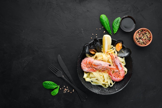 Macarrão com frutos do mar e limão em um prato mexilhões de camarão no fundo antigo vista superior espaço livre para o seu texto