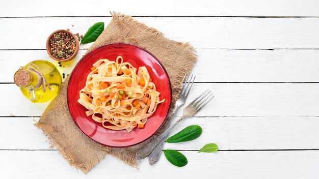 Macarrão com legumes e molho de tomate em um prato No fundo antigo Vista superior Espaço livre para o seu texto