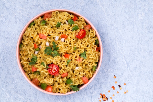 Macarrão com legumes em uma tigela rosa