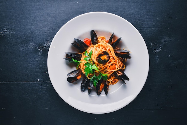 Macarrão com mexilhões e frutos do mar comida tradicional italiana em um fundo de madeira vista superior espaço livre para o seu texto