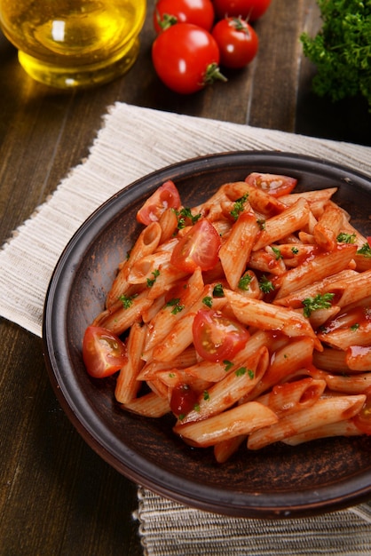 Macarrão com molho de tomate no prato na mesa closeup