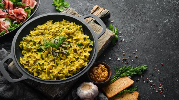 Macarrão com molho pesto cozimento instantâneo em uma frigideira Vista superior Espaço livre para seu texto Estilo rústico