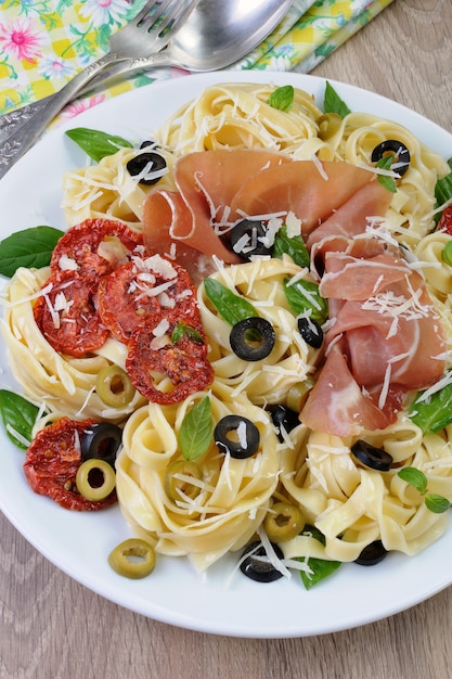 Macarrão com pernil, azeitonas, tomate seco e parmesão