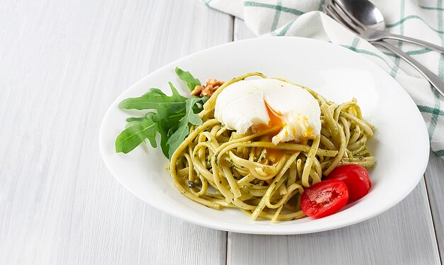 Macarrão com pesto de rúcula e ovo escalfado em fundo branco horizontal sem pessoas