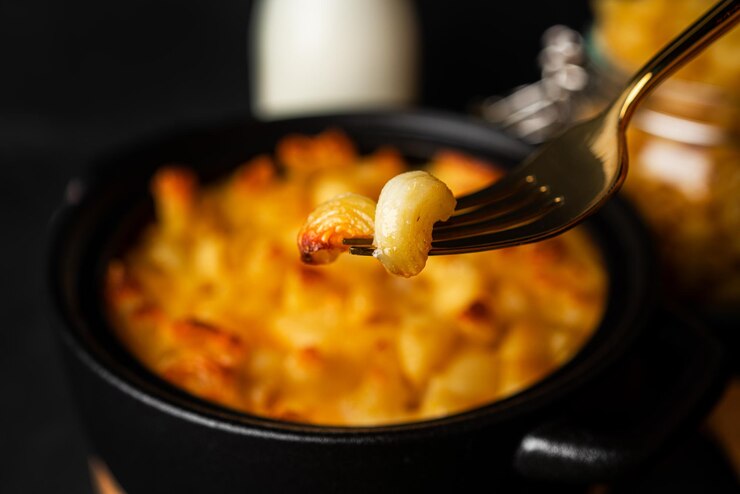 Macarrão com queijo, macarrão estilo americano macarrão com molho de queijo em fundo escuro. Foto de alta qualidade