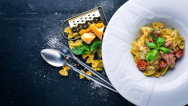 Macarrão com tomate e manjericão prato com a palavra colar vista superior espaço livre para texto em um fundo de madeira