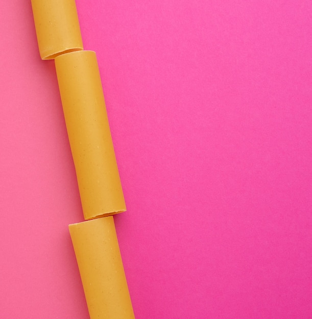 Foto macarrão cru de canelone em um espaço rosa