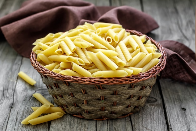 Macarrão cru em uma cesta de vime