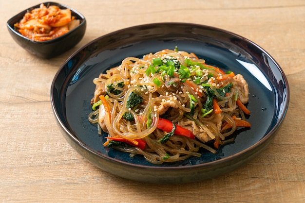 Macarrão de aletria coreana japonesa ou refogada com vegetais e carne de porco coberta com gergelim branco - estilo tradicional de comida coreana