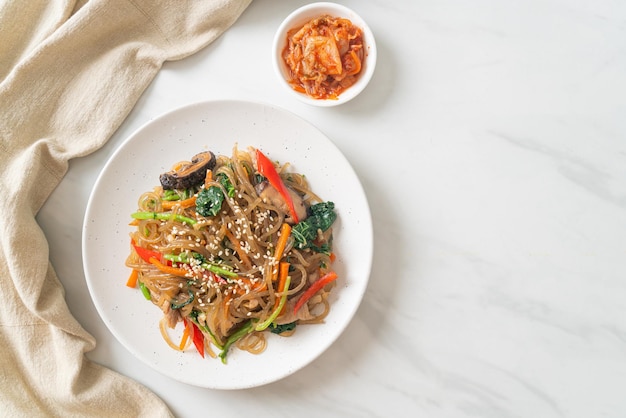 Macarrão de aletria coreana japonesa ou refogada com vegetais e carne de porco coberta com gergelim branco - estilo tradicional de comida coreana